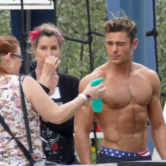 Zac Efron très musclé (il se fait vaporiser de l'huile sur le corps) sur le tournage de Baywatch à Miami Beach, le 5 mars 2016.
