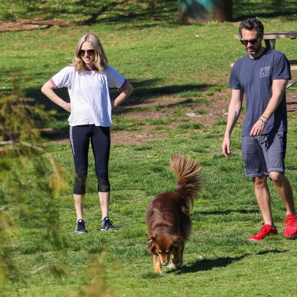 Thomas Sadoski et Amanda Seyfried se baladent en amoureux et profitent du soleil avec le chien de l'actrice, dans un parc de Los Angeles, le 16 mars 2016.