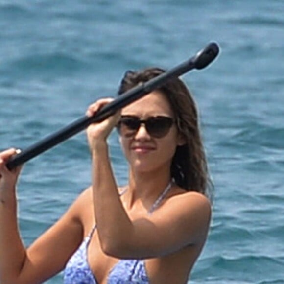 Jessica Alba profite d'une belle journée ensoleillée pour bronzer et faire du paddle sur une plage à Maui à Hawaii. Son mari Cash Warren se baigne seul en attendant. Le  22 mars 2016.