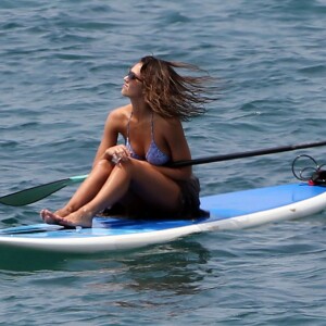 Jessica Alba profite d'une belle journée ensoleillée pour bronzer et faire du paddle sur une plage à Maui à Hawaii. Son mari Cash Warren se baigne seul en attendant. Le  22 mars 2016.
