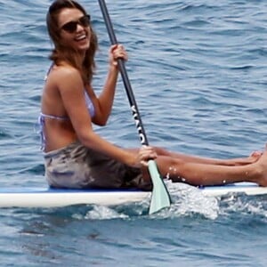 Jessica Alba profite d'une belle journée ensoleillée pour bronzer et faire du paddle sur une plage à Maui à Hawaii. Son mari Cash Warren se baigne seul en attendant. Le  22 mars 2016.