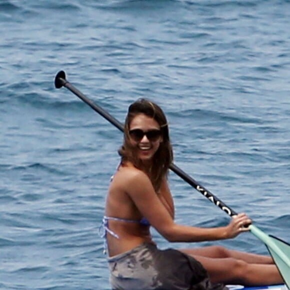 Jessica Alba profite d'une belle journée ensoleillée pour bronzer et faire du paddle sur une plage à Maui à Hawaii. Son mari Cash Warren se baigne seul en attendant. Le  22 mars 2016.