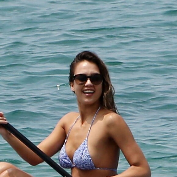 Jessica Alba profite d'une belle journée ensoleillée pour bronzer et faire du paddle sur une plage à Maui à Hawaii. Son mari Cash Warren se baigne seul en attendant. Le  22 mars 2016.