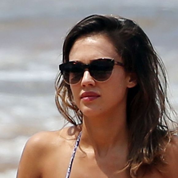 Jessica Alba profite d'une belle journée ensoleillée pour bronzer et faire du paddle sur une plage à Maui à Hawaii. Son mari Cash Warren se baigne seul en attendant. Le  22 mars 2016.