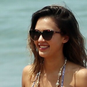 Jessica Alba profite d'une belle journée ensoleillée pour bronzer et faire du paddle sur une plage à Maui à Hawaii. Son mari Cash Warren se baigne seul en attendant. Le  22 mars 2016.