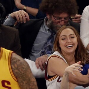 Miley Cyrus, sa grande soeur Brandi et Victor Cruz (New York Giants, NFL) assistent au match de NBA New York Knicks vs. Cleveland Cavaliers au Madison Square Garden. New York, le 26 mars 2016.