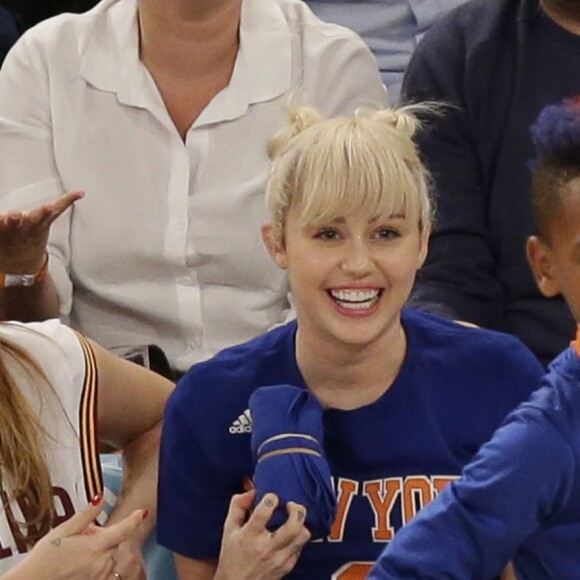 Miley Cyrus, sa grande soeur Brandi et Victor Cruz (New York Giants, NFL) assistent au match de NBA New York Knicks vs. Cleveland Cavaliers au Madison Square Garden. New York, le 26 mars 2016.