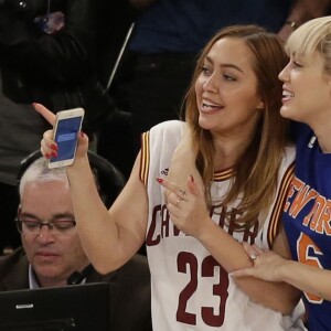 Miley Cyrus et sa grande soeur Brandi lors du match de NBA New York Knicks vs. Cleveland Cavaliers au Madison Square Garden. New York, le 26 mars 2016.