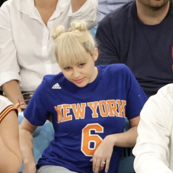 Miley Cyrus, sa grande soeur Brandi et Victor Cruz (New York Giants, NFL) assistent au match de NBA New York Knicks vs. Cleveland Cavaliers au Madison Square Garden. New York, le 26 mars 2016.