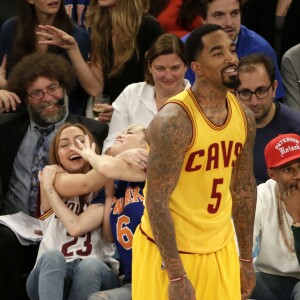 Miley Cyrus, sa grande soeur Brandi et Victor Cruz (New York Giants, NFL) assistent au match de NBA New York Knicks vs. Cleveland Cavaliers au Madison Square Garden. New York, le 26 mars 2016.