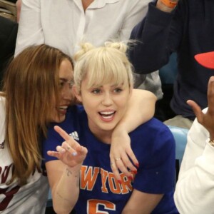 Miley Cyrus, sa grande soeur Brandi et Victor Cruz (New York Giants, NFL) assistent au match de NBA New York Knicks vs. Cleveland Cavaliers au Madison Square Garden. New York, le 26 mars 2016.