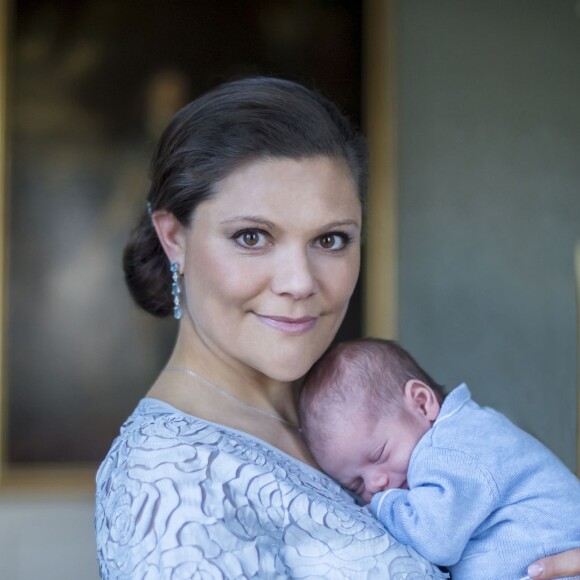 Photo officielle, par Kate Gabor, du prince Oscar de Suède dans les bras de sa maman la princesse Victoria.