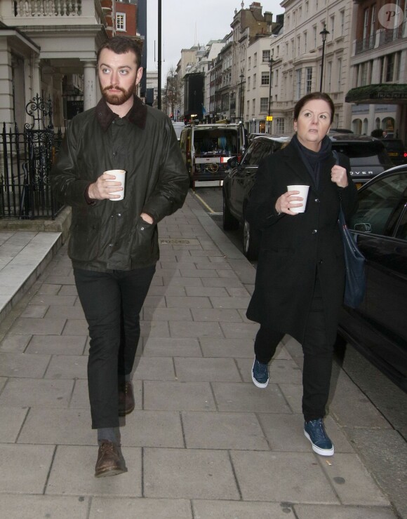 Le chanteur Sam Smith, qui a reçu l'Oscar de la meilleure chanson originale pour "Writing on the wall", quitte la boutique d'un barbier à Londres avec une amie le 8 mars 2016.