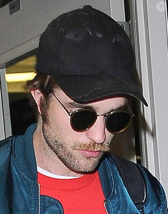 Exclusif - Robert Pattinson a une moustache et une barbe à son arrivée à l'aéroport de LAX à Los Angeles, le 24 octobre 2014.