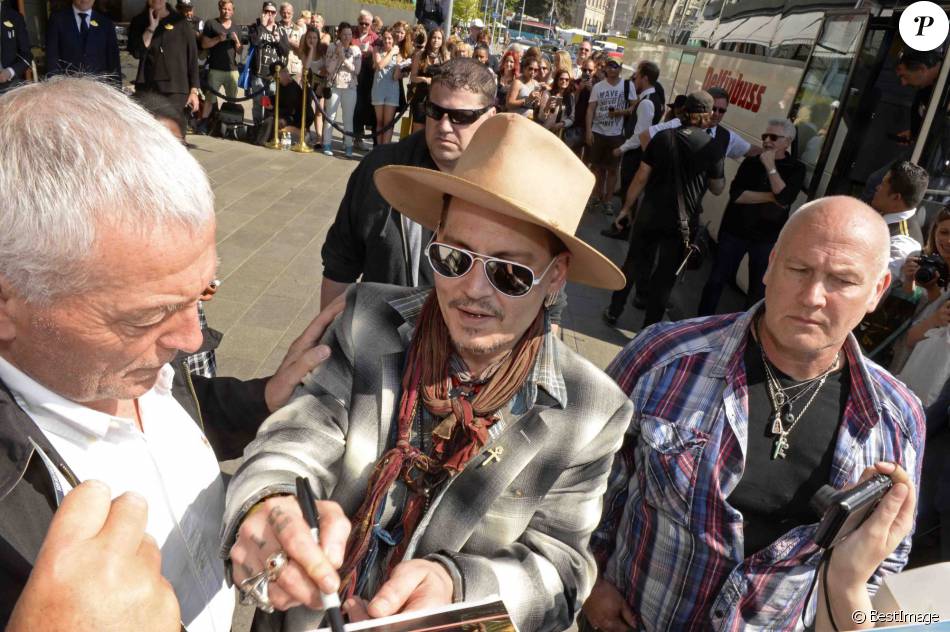 Johnny Depp signe des autographes à ses fans à la sortie du Grand Hôtel