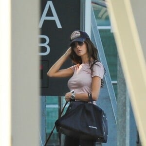 Exclusif - Nabilla Benattia arrive à l'aéroport de Mérignac avec son compagnon Thomas Vergara et leur chien Pita après avoir dédicacé son livre "Trop Vite", le 26 juin 2016. Elle porte une casquette avec l'inscription "Prison"!