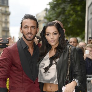 Nabilla Benattia embrasse son compagnon Thomas, lorsqu'elle arrive au defile de mode Jean-Paul Gaultier a Paris. Le 3 juillet 2013