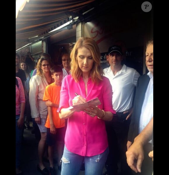 Céline Dion signe des autographes devant le restaurant Schwartz's, à Montréal, le 23 août 2016.