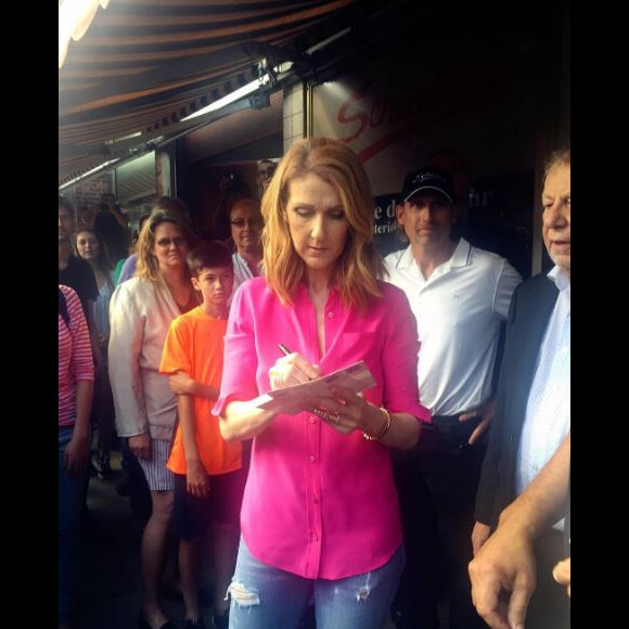 Céline Dion signe des autographes devant le restaurant Schwartz's, à Montréal, le 23 août 2016.