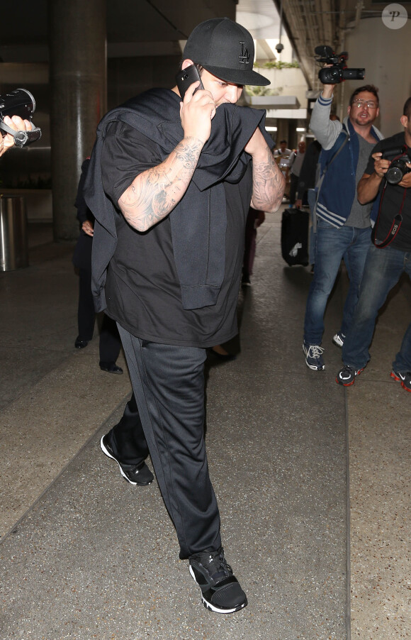 Rob Kardashian arrive à l'aéroport de LAX à Los Angeles. Rob n'a pas assisté au mariage de sa soeur Kim Kardashian et de Kanye West et les a traités de superficiels! Le 24 mai 2014 Rob Kardashian arriving on a flight at LAX airport in Los Angeles, California on May 24, 2014. Rob skipped out on his sister Kim Kardashian and Kanye West's wedding.24/05/2014 - Los Angeles