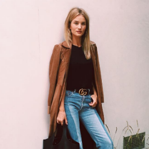 Photo de Rosie Huntington-Whiteley publiée le 13 septembre 2016, habillée d'un manteau en cuir Reformation, d'un t-shirt noir, d'un jean et de bottines Vetements. Un sac Tom Ford et une ceinture Gucci accessoirisent sa tenue.