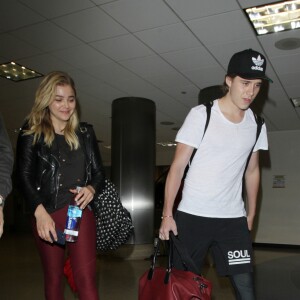 Chloë Grace Moretz et son compagnon Brooklyn Beckham arrivent à l'aéroport de LAX main dans la main à Los Angeles, Californie, le 30 juin 2016.