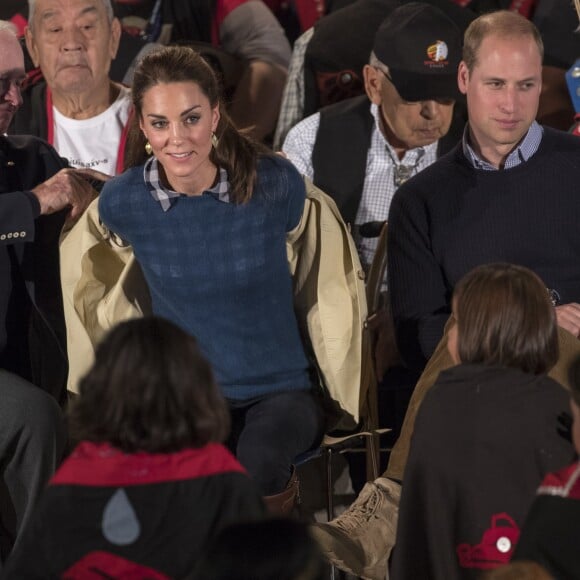 La duchesse Catherine enlève son trench Holland and Holland lors de la cérémonie. Kate Middleton et le prince William, duchesse et duc de Cambridge, ont pris part à une cérémonie de bienvenue traditionnelle lors de leur rencontre avec la nation Heiltsuk à la réserve amérindienne de Bella Bella le 26 septembre 2016, au troisième jour de leur visite officielle au Canada.