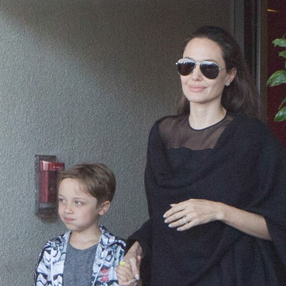 Angelina Jolie arrive à l'aéroport de Los Angeles avec ses fils Knox et Maddox en provenance de New York, le 20 juin 2016. Knox, qui tient la main de sa mère, porte une peluche requin.