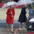 L'infante Sofia d'Espagne (en manteau rouge) et la princesse Leonor des Asturies (en manteau bleu), filles du roi Felipe VI et de la reine Letizia, ont bravé la pluie à Madrid le 12 octobre 2016 lors des célébrations de la Fête nationale.