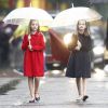 L'infante Sofia d'Espagne (en manteau rouge) et la princesse Leonor des Asturies (en manteau bleu), filles du roi Felipe VI et de la reine Letizia, ont bravé la pluie à Madrid le 12 octobre 2016 lors des célébrations de la Fête nationale.