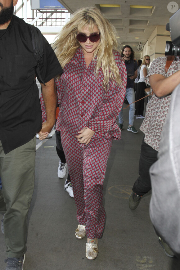 Kesha arrive à l'aéroport LAX de Los Angeles habillée d'un pyjama de soie le 16 septembre 2016. © CPA / Bestimage