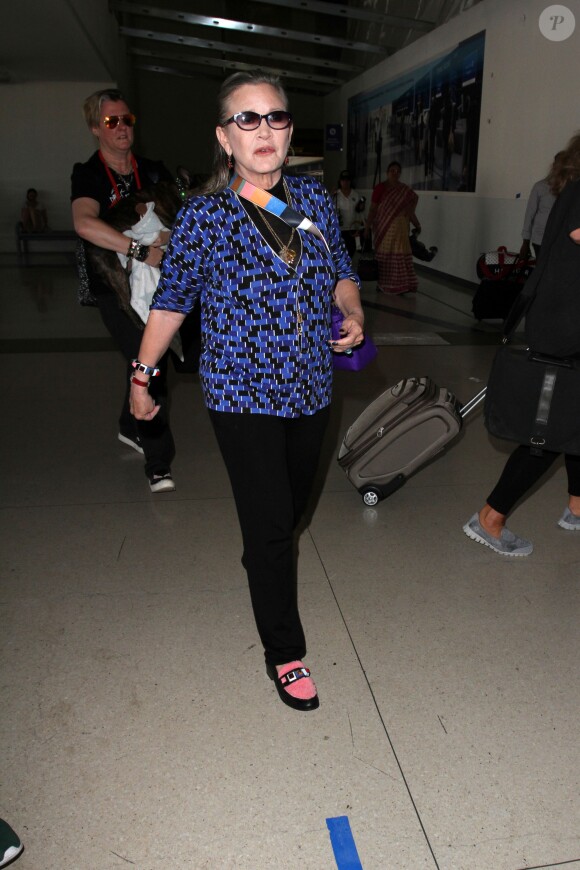 Carrie Fisher et son chien Gary arrivent à l'aéroport Lax de Los Angeles le 19 aout 2016.