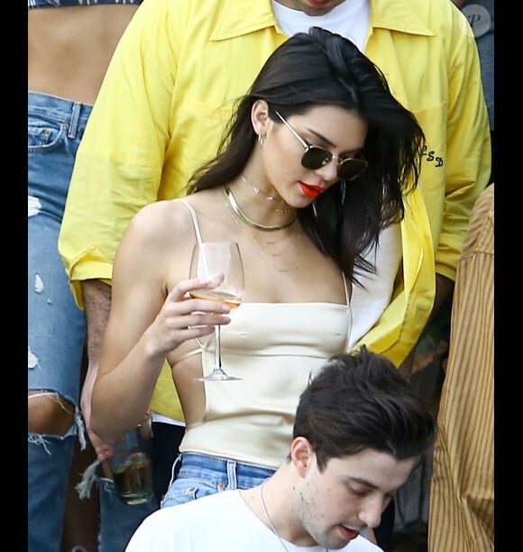 Kendall Jenner se balade, s'amuse, discute et boit un verre avec des amis sur une plage à Miami, le 4 décembre 2016