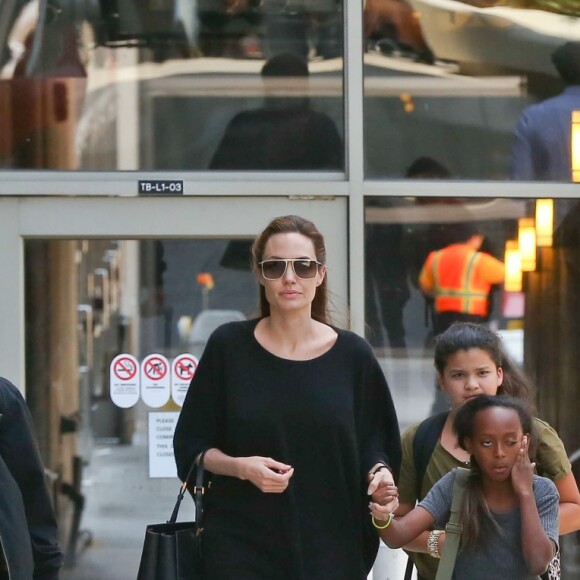 Angelina Jolie et Brad Pitt avec leurs enfants en juin 2014 à l'aéroport LAX de Los Angeles.