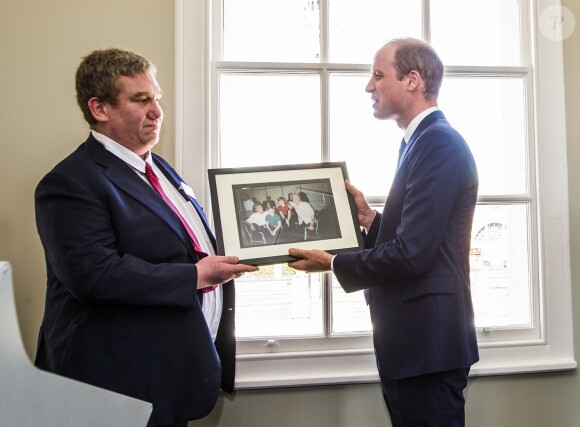 Le prince William, duc de Cambridge, en visite le 13 mai 2016 dans les locaux de l'organisation "The Passage", qui aide les sans-abris à retrouver une vie meilleure, à Londres. A l'occasion de sa visite, il a reçu en cadeau une photo de sa mère Diana et de son frère Harry prise en 1994 dans ce même endroit.