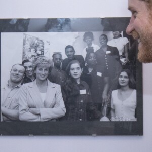 Le prince Harry en visite dans un foyer auprès de l'association The Running Charity qui aide les jeunes sans-abri, le 26 janvier 2017 à Londres. Sa mère Lady Diana avait inauguré le foyer dans les années 1990, comme une photo d'époque en témoigne.