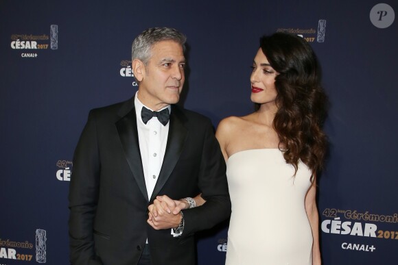 George Clooney (montre Omega) et sa femme Amal Alamuddin-Clooney enceinte (robe Atelier Versace) arrivant à la 42e cérémonie des César à la Salle Pleyel à Paris le 24 février 2017. © Olivier Borde / Dominique Jacovides / Bestimag