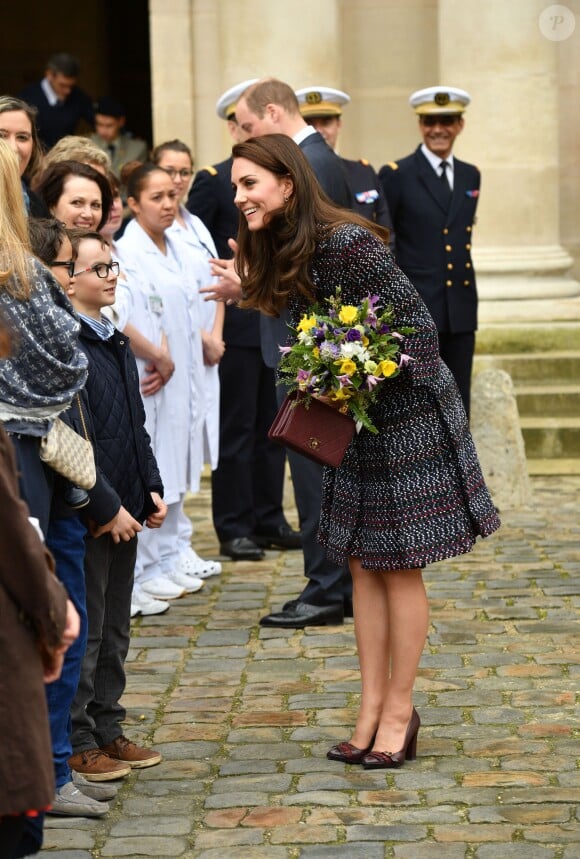 Le prince William et Kate Middleton visitent les Invalides à Paris le 18 mars 2017. La duchesse de Cambridge a rendu hommage à la France en choisissant un manteau, un sac et une ceinture Chanel.