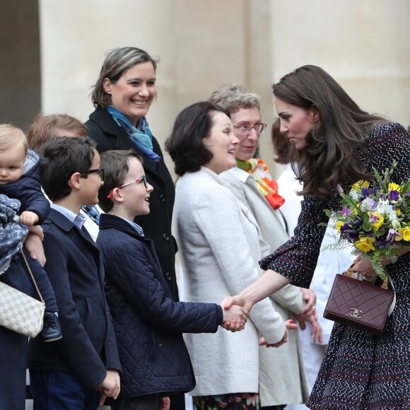 Le prince William et Kate Middleton visitent les Invalides à Paris le 18 mars 2017. La duchesse de Cambridge a rendu hommage à la France en choisissant un manteau, un sac et une ceinture Chanel.