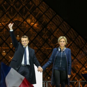 Emmanuel Macron, élu président de la république, et sa femme Brigitte Macron (Trogneux), saluent les militants devant la pyramide au musée du Louvre à Paris, après sa victoire lors du deuxième tour de l'élection présidentielle. Le 7 mai 2017.