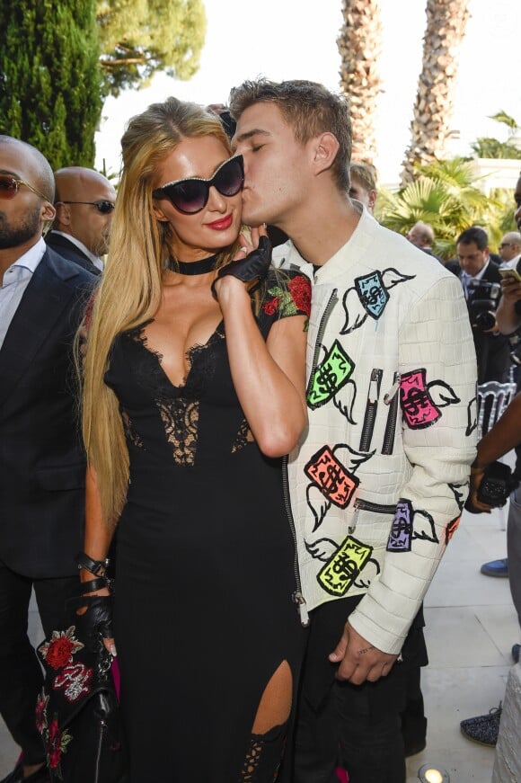 Paris Hilton et son compagnon Chris Zylka  au défilé de mode Philipp Plein dans la villa "La Jungle du Roi" lors du 70ème festival de Cannes le 24 mai 2017.