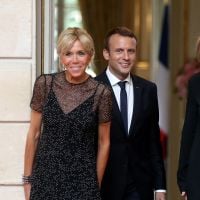 Brigitte Macron, en robe noire et brillante, main dans la main avec Emmanuel