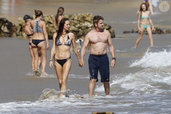 Gerard Butler et sa compagne Morgan Brown s'embrassent sur la plage de Malibu le 12 octobre 2015.