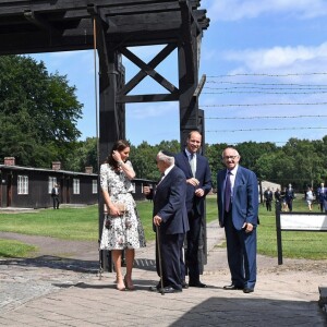 Le prince William et la duchesse Catherine de Cambridge franchissant la "porte de la mort" lors de leur visite le 18 juillet 2017 de l'ancien camp de concentration de Stutthof, près de Gdansk, au cours de leur visite officielle en Pologne, le premier établi par les nazis dans le pays, en 1939, et l'un des derniers libérés par les Alliés, en 1945.