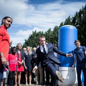 Le président de la République Emmanuel Macron rencontre avec Valérie Pécresse, présidente de la région Ile-de-France des enfants qui ne partent pas en vacances sur la Base de plein air et de loisirs des Boucles de Seine à Moisson, le 3 août 2017. Certains enfants portent des tee-shirts de la fondation du © Nicolas Messyasz/Pool/Bestimage