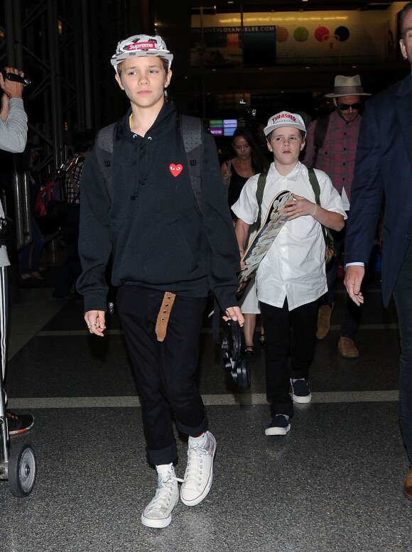 David, Cruz et Romeo Beckham (habillé d'une casquette Supreme, d'un pull Comme des Garçons Play et de baskets Converse) à l'aéroport de LAX à Los Angeles. Le 17 avril 2017.