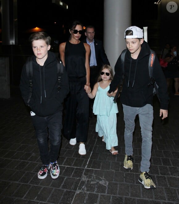 Victoria Beckham et ses enfants Cruz, Harper et Romeo (chaussée de baskets adidas NMD) à l'aéroport LAX. Los Angeles, le 18 avril 2016.