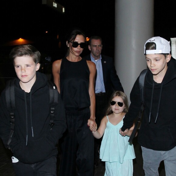 Victoria Beckham et ses enfants Cruz, Harper et Romeo (chaussée de baskets adidas NMD) à l'aéroport LAX. Los Angeles, le 18 avril 2016.