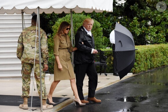 Le président Donald J. Trump et la première dame Melania Trump sortent sous la pluie de la Maison Blanche à Washington, DC. Donald Trump et son épouse Melania ont rendu visite à des rescapés de la tempête Harvey au Texas le 2 septembre 2017.