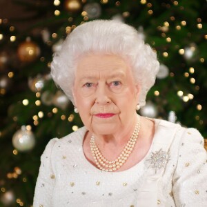 La reine Elizabeth II dans le salon 1844 au palais de Buckingham pour l'enregistrement de son allocution de Noël, le 25 décembre 2017. Sur le bureau à côté d'elle, des photos de George et Charlotte de Cambridge, de son mariage avec le prince Philip et de leurs noces de platine. Mais dans la pièce figurait aussi une photo des fiançailles du prince Harry et de Meghan Markle, qui s'apprête à entrer dans la famille.